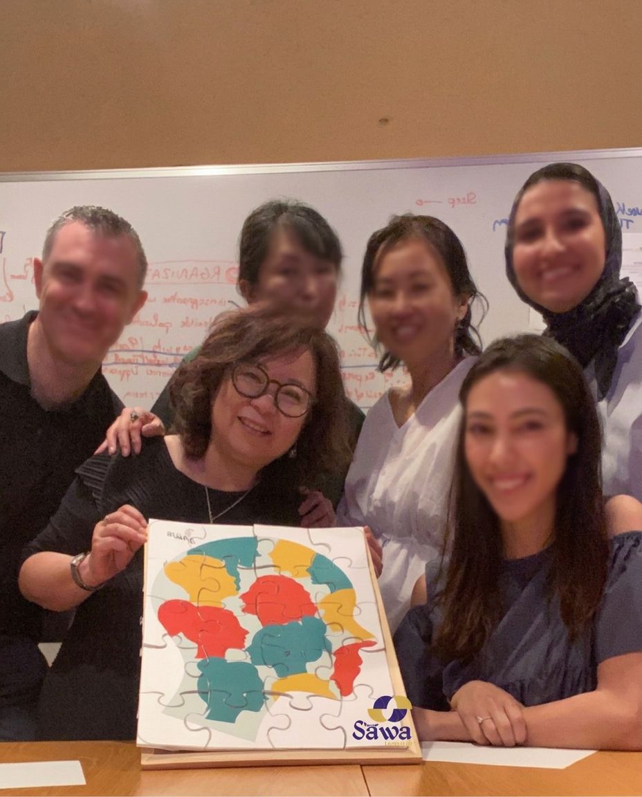 A team holding a colourful co created canvas after a workshop