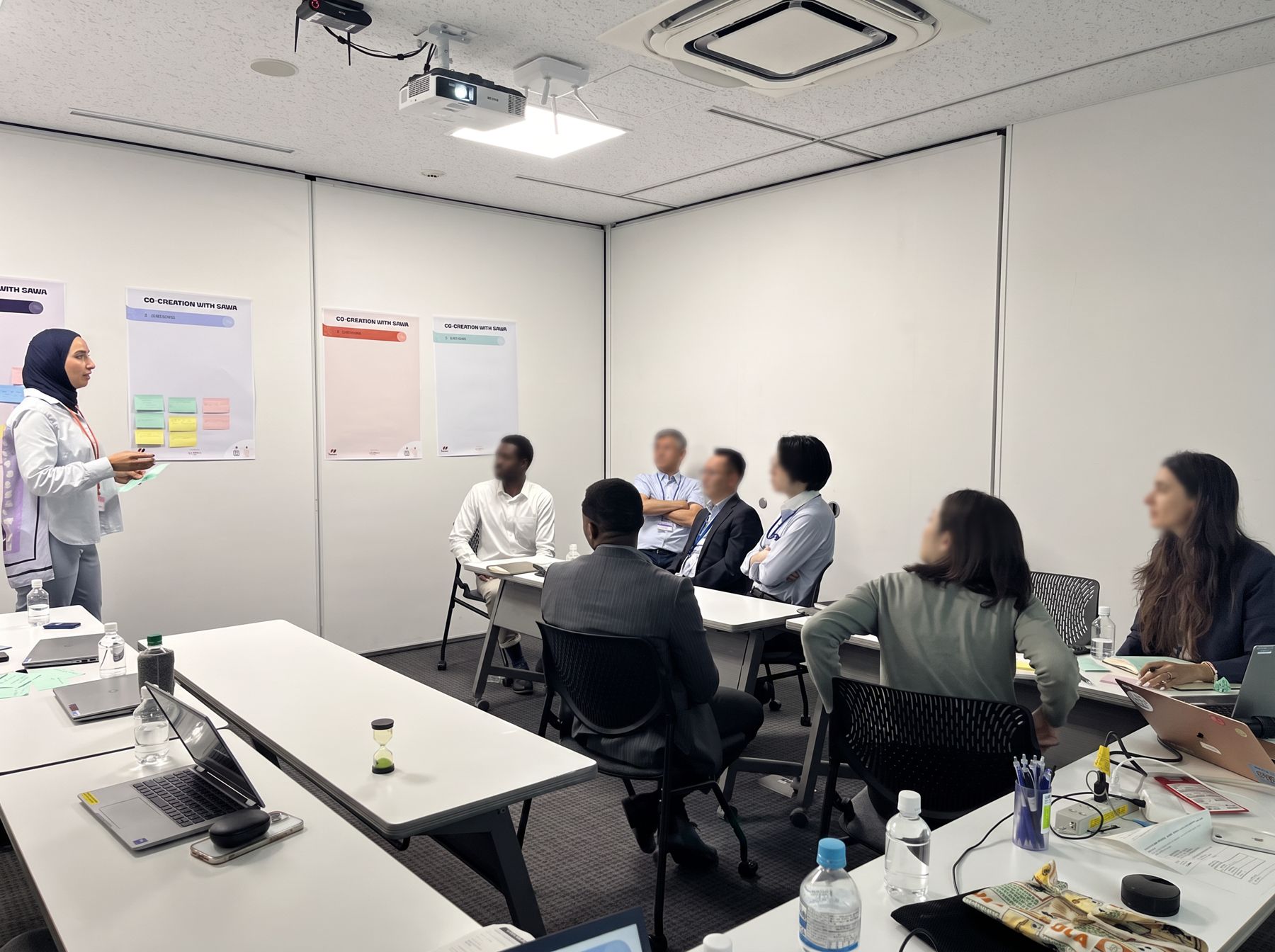 A facilitator presenting to seated participants in a classroom