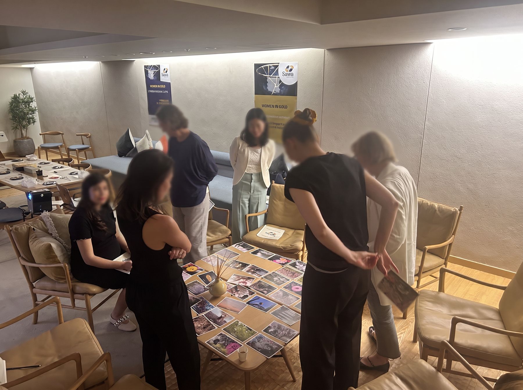 Participants gathered around image cards laid out on the floor during a reflective exercise