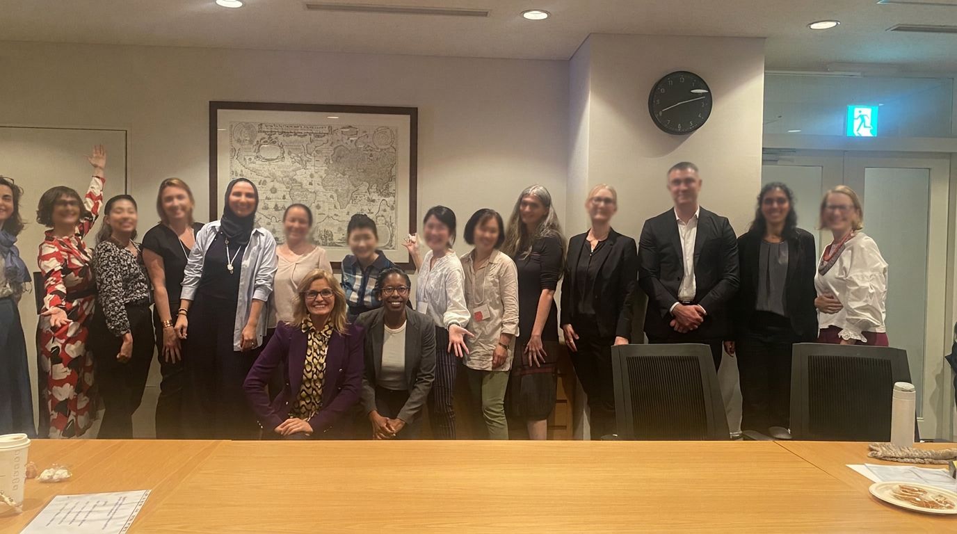 A large group photo of participants in a conference room